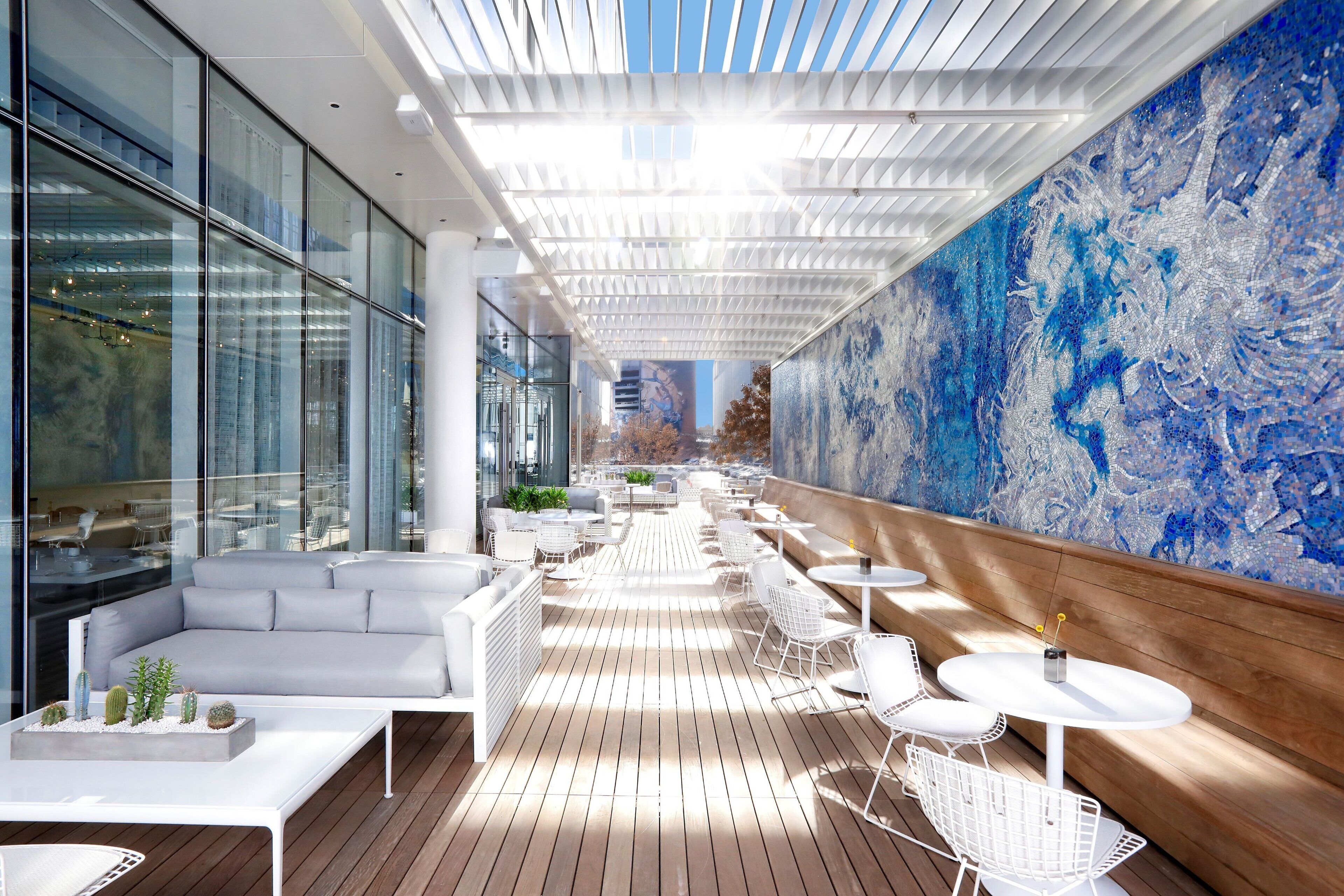 Shared outdoor seating and contemporary mural at HALL Arts Hotel