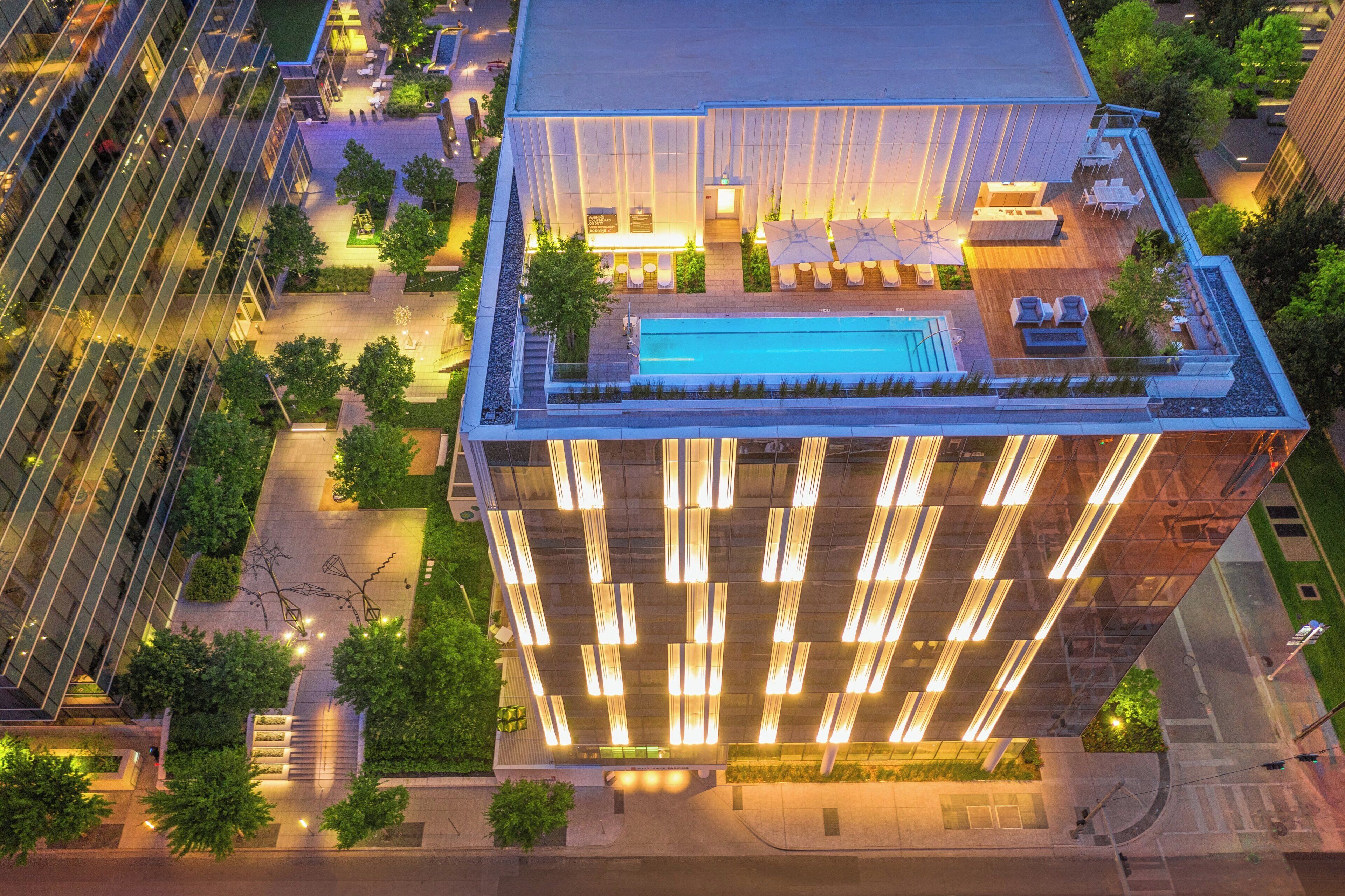 Illuminated rooftop pool at HALL Arts Hotel in Dallas